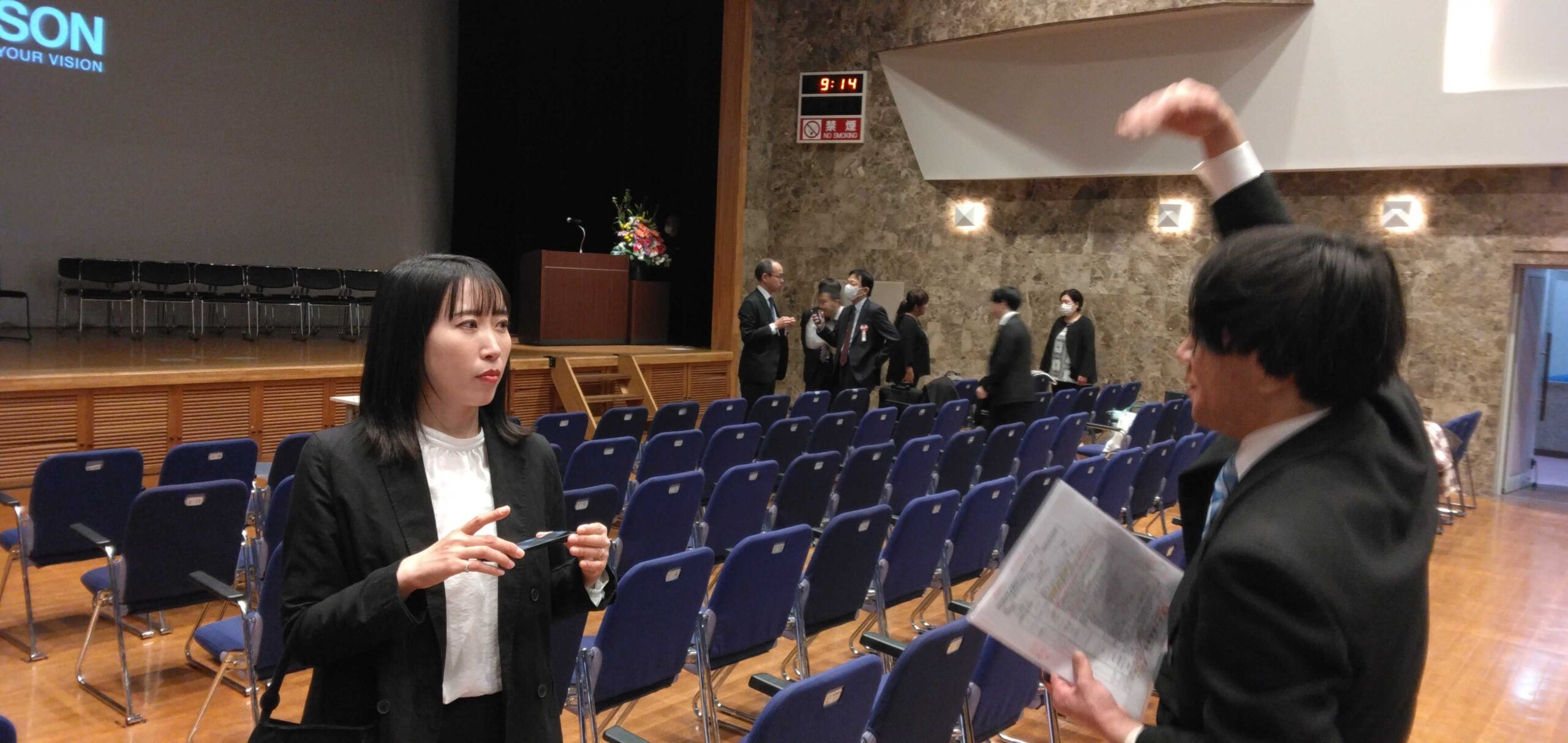 日本語学校の入学式会場で打ち合わせをする教員