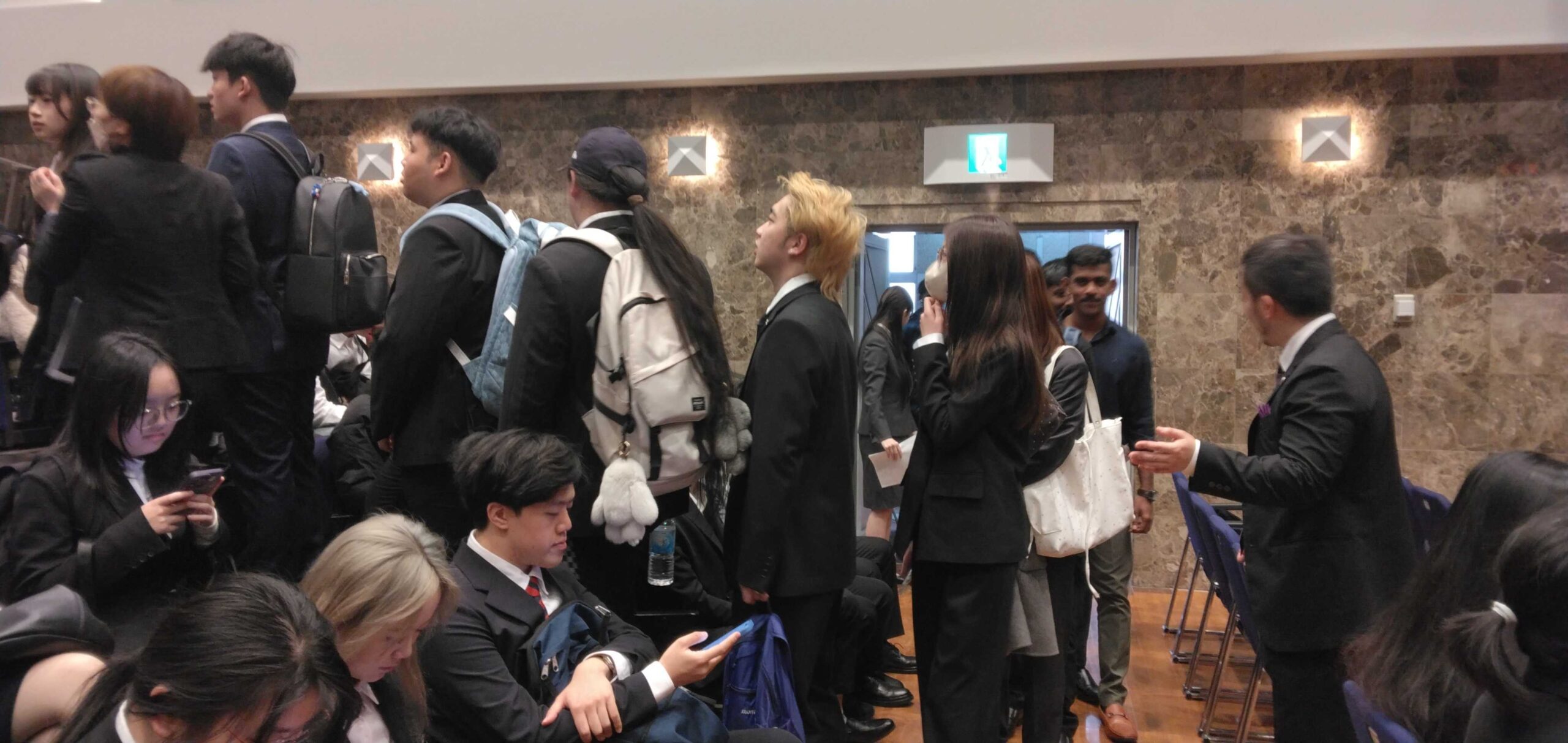 入学式会場で留学生を誘導する教員